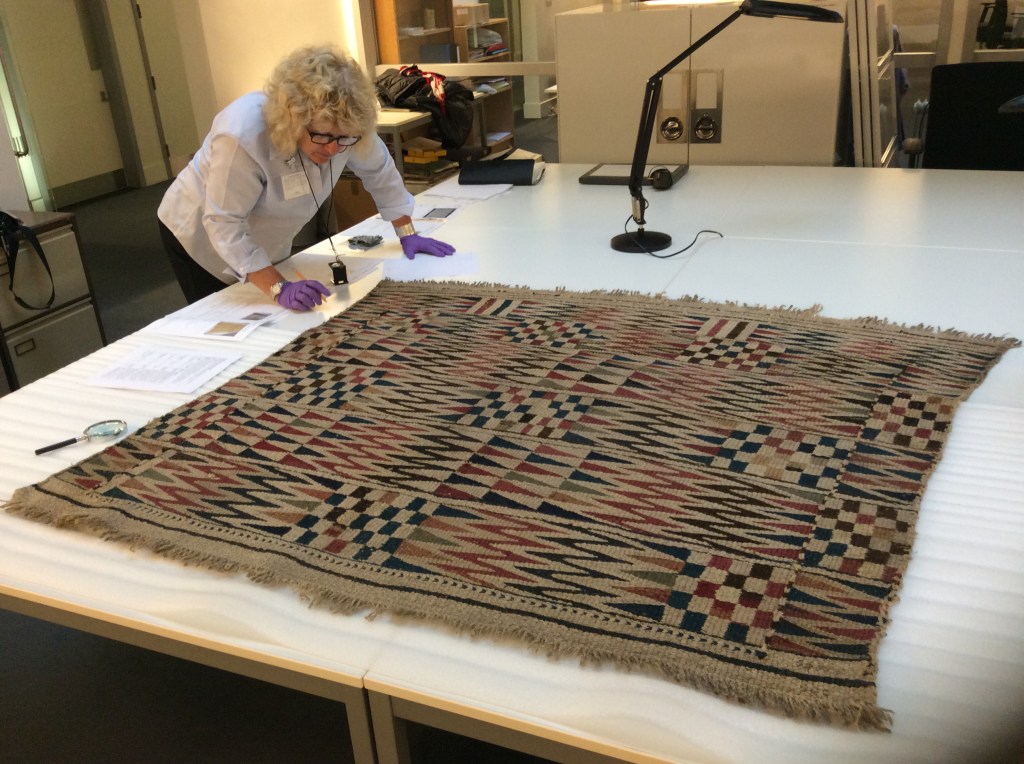 Taking a close look at a blanket at the Pitt Rivers Museum, Oxford.